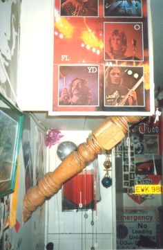 a wooden stick is hanging from the ceiling in a room with posters and other items