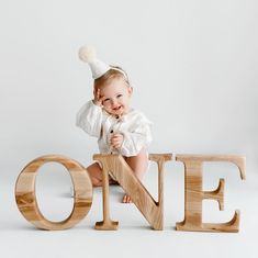 a baby sitting on top of the word one