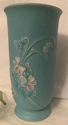 a blue vase with flowers painted on it