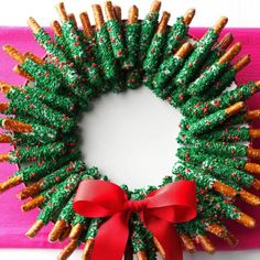 a christmas wreath made out of pretzels with a red bow on it's front