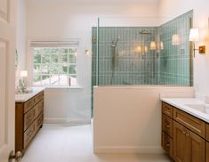 a bathroom with two sinks and a walk in shower