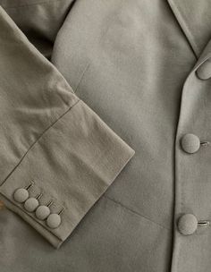 "Well tailored double breasted wool coat by Morty Sills has covered buttons in the front, on the cuffs and in the back. Coat is lined in a taupe satin and has two inside pockets, slight shoulder pads and a back kickpleat. In excellent vintage condition The Morty Sills brand has been referred to as \"the tailor to the CEO\". Morty Sills specialized in high-end formal/semi-formal wear for men and women. Handcrafted in the USA. Shoulders 17\" Chest 40\" Waist 36\" Hips 42\" Length from back of neck Elegant Long Coat Blazer In Solid Color, Formal Button-up Outerwear With Button Cuffs, Classic Khaki Blazer With Button Cuffs, Beige Formal Blazer With Button Cuffs, Formal Beige Blazer With Button Cuffs, Double-breasted Blazer With Button Cuffs, Classic Double-breasted Suit With Button Cuffs, Classic Double-breasted Suits With Button Cuffs, Classic Gray Outerwear With Button Cuffs