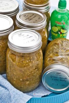 several jars filled with pickles sitting on top of a blue towel