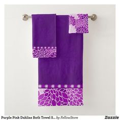 two purple towels hanging on a towel rack