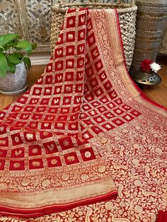 An exquisite pure khaddi georgette saree in a rich deep red shade with golden zari jaal benarasi work in kadua style. This saree is truly stunning. The pallu and border has dense floral and fauna designs and the gold really stands out beautifully. The fabric is extremely soft and drapes really well. It has a great fall and is very comfortable. The gorgeous animal motifs with the intricate borders create a very rich and royal look, perfect to add to your wedding trousseau or for any special occas Red Semi-stitched Ceremonial Saree, Red Semi-stitched Saree For Ceremonial Occasions, Ceremonial Red Semi-stitched Saree, Red Georgette Saree With Motifs, Red Ceremonial Saree With Zari Weaving, Red Motif Saree For Ceremonial Occasions, Red Saree With Zari Weaving For Ceremonial Occasions, Ceremonial Red Saree With Motifs, Ceremonial Red Motifs Saree