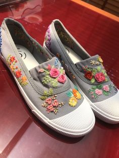 a pair of gray shoes with colorful flowers on them