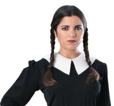 a woman with long hair wearing a black dress and white collared shirt, standing in front of a white background