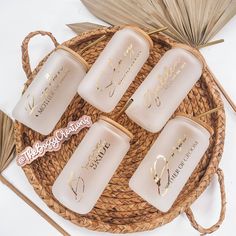 four candles sitting on top of a wicker basket next to palm leaves and an umbrella