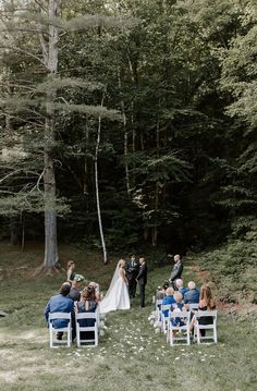 a bride and groom are getting married in the woods