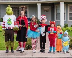 a group of children dressed up in costumes standing on the sidewalk with dr seuss and cat in the hat