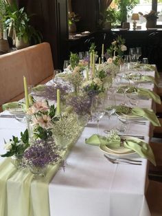 a long table is set with flowers and candles