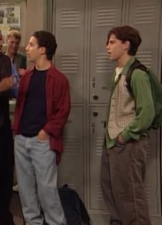 the young men are standing in front of lockers