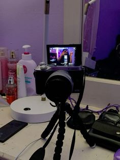 a camera sitting on top of a table next to a mirror and hair dryer