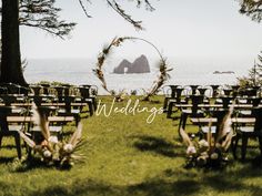 an outdoor ceremony set up with chairs and flowers in the foreground, overlooking the ocean