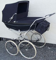 a baby carriage sitting next to a wall