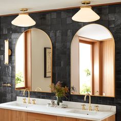 a bathroom with double sinks and two mirrors on the wall next to eachother