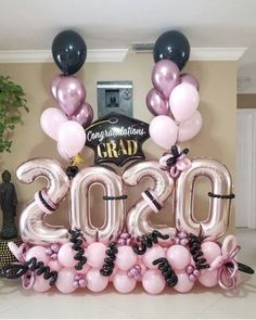 balloons and streamers are arranged in the shape of numbers for graduation party decorations on display