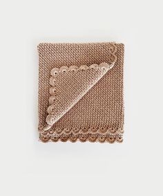 a brown knitted blanket with scalloped edges