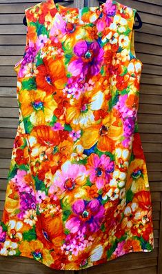 This vintage 1970's Channel 1 by Bill Sims brand sleeveless A-line dress in size 20 ½ is the perfect summer dress Stylized, colorful flowers are scattered across this dress.  Features include darts at the bust and on either side of the back zipper to give shape to this garment as well as a side pocket.  The traditional A-line design is classic, but the fabric design makes it stand out.  Dress it up with a jacket for work or add accessories for any casual or formal event this summer.   Size: 20 ½ Hawaiian Clothing, Hawaiian Outfit, Line Design, Dress Clothes For Women, Side Pocket, Perfect Summer, Colorful Flowers, Formal Event, Size 20