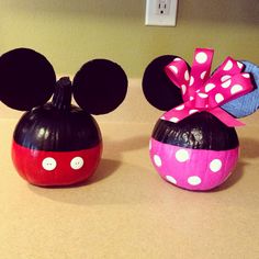 two mickey mouse pumpkins with bows on them