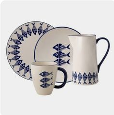 a blue and white dinnerware set with fish design