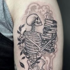 a tattoo with a skeleton and books on it