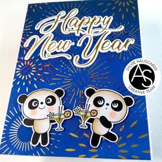 a card with two pandas holding champagne glasses in front of fireworks and the words happy new year