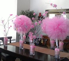 vases filled with pink flowers on top of a wooden table