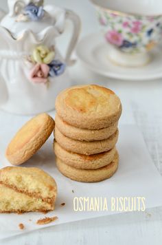 a stack of cookies sitting on top of a piece of paper next to a cup and saucer