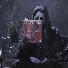 a person sitting on a bench with a book in their hands and a mask covering his face