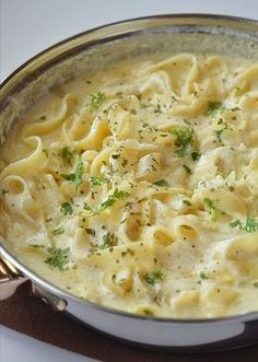 a pot filled with pasta and sauce on top of a stove