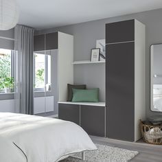 a bedroom with gray and white walls, a large mirror on the wall