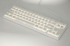 a white computer keyboard sitting on top of a table