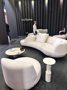 two children are sitting on the couches in front of a black curtained wall