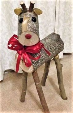 a wooden reindeer sitting on top of a piece of wood with a red ribbon around it's neck