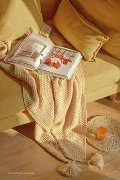 an open book sitting on top of a table next to a straw hat and orange juice