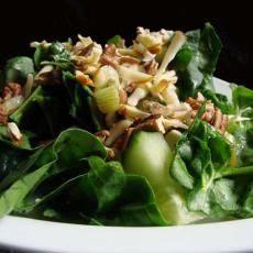 a white plate topped with spinach salad and toppings