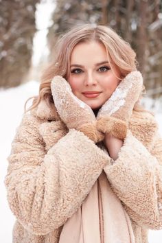 a beautiful blonde woman in a fur coat and mittens posing for the camera