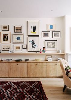 a living room filled with furniture and framed pictures on the wall above it's entertainment center