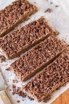 three pieces of chocolate cake sitting on top of a cutting board