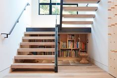 the stairs are made of wood and have bookshelves on each side, along with a bookcase full of books