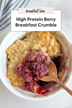 high protein berry breakfast crumble in a white bowl with a wooden spoon on the side