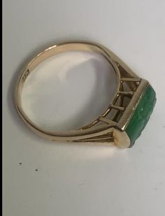 The jade is carved with a flower and is a bright emerald green with a stem and scroll., beautifully displayed in a raised gold cage, and bezel set in 14k yellow gold women's jewelry. Although antique, this jade ring has a contemporary look that complements today's tastes. Specifications: Metal: 14K Yellow Gold Style: Statement Ring Ring Size: 4 Gemstone Specifications: Center Gemstone: Jade Shape: RectangularColor: GreenCut: Cabochon Boxed - Only One Available Free shipping via USPS in 2 - 7 Day Chinese Jade, Jade Ring, Style Statement, Ring Ring, Gold Style, Bezel Setting, Statement Ring, A Flower, Emerald Green