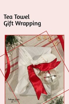 a tea towel wrapped in red ribbon next to a christmas ornament on the ground