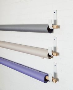 three different colored yoga mats are hanging on the wall