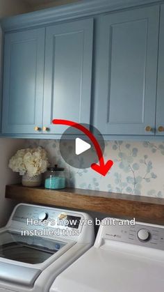 a washer and dryer sitting in a kitchen next to blue cabinets with red arrow pointing up