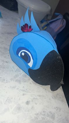 a paper mache with a blue bird on it's head sitting on a counter