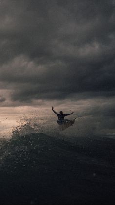 a man riding a wave on top of a surfboard in the middle of the ocean