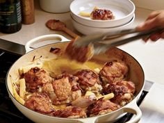 someone is cooking chicken and pasta in a skillet on the stove top with a spatula