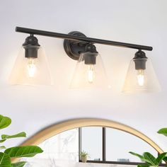 three light bathroom fixture with clear glass shades on the top and bottom lights in black finish